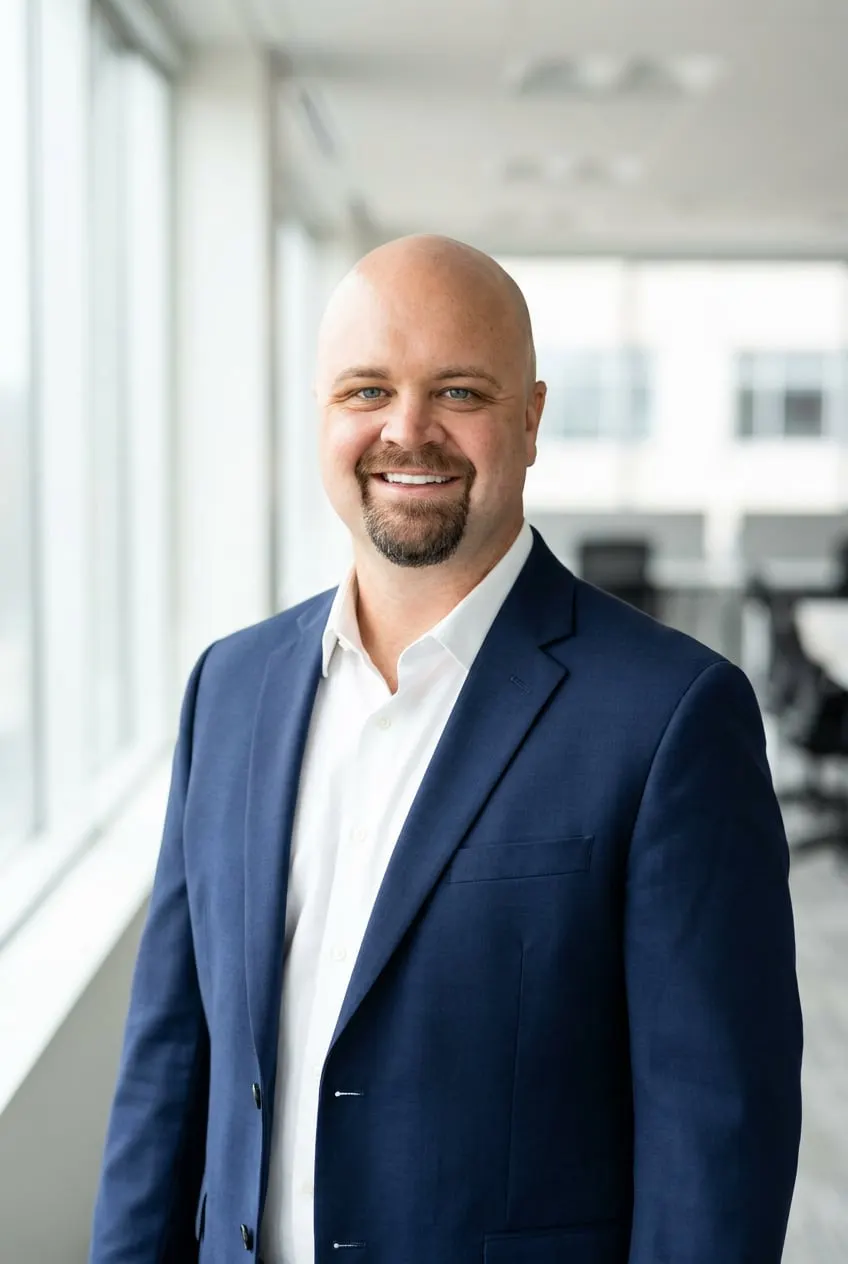 Michael Blair in a navy blazer, smiling, in a bright office